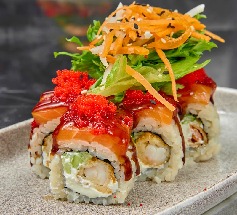 Внутри креветка, сыр и огурец, сверху лосось унаги и икра масаго