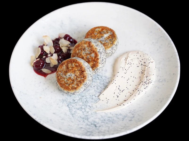 Сырники с маком, творожным кремом и вишневым соусом