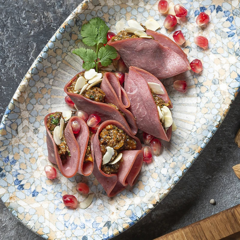 Закуска из копченой говядины с сухофруктами, орехами и зеленью.