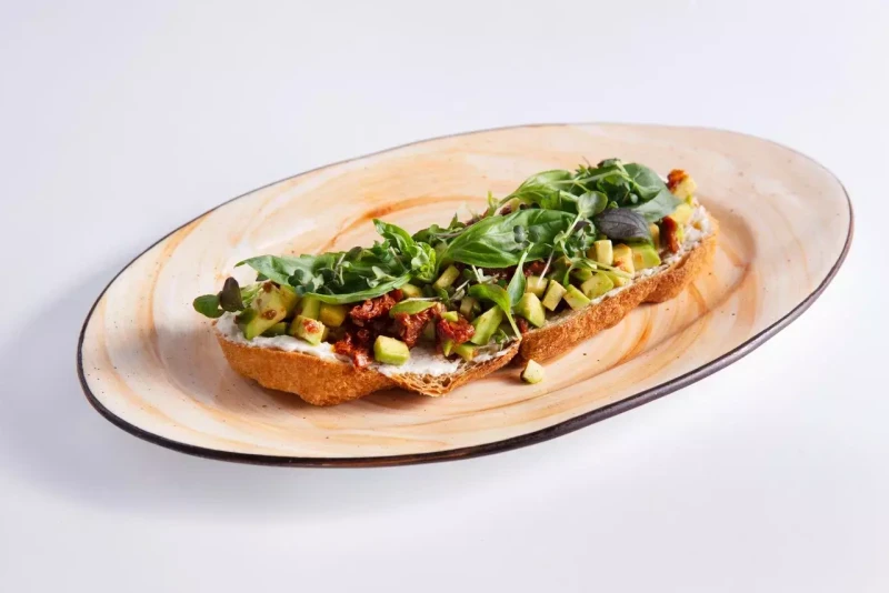 Брускетта с авокадо, вяленными томатами и двумя видами сыра